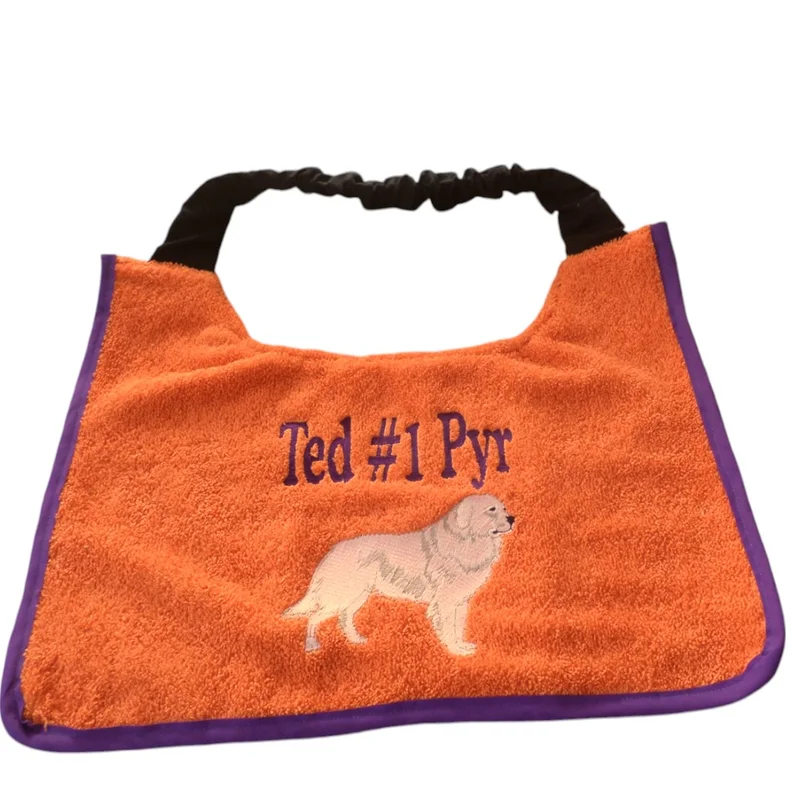 Orange towelling Pyrenean Mountain Dog bib embroidered with Ted #1 Pyr and a white Pyrenean dog